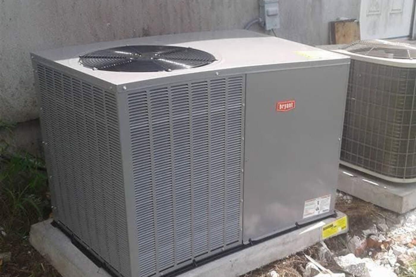 A newly installed outdoor unit standing on its pad beside the house.