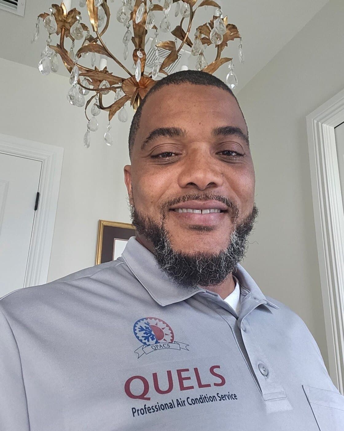 Quel Moragne, owner of Quel's Professional Air Condition Services, in a company shirt.